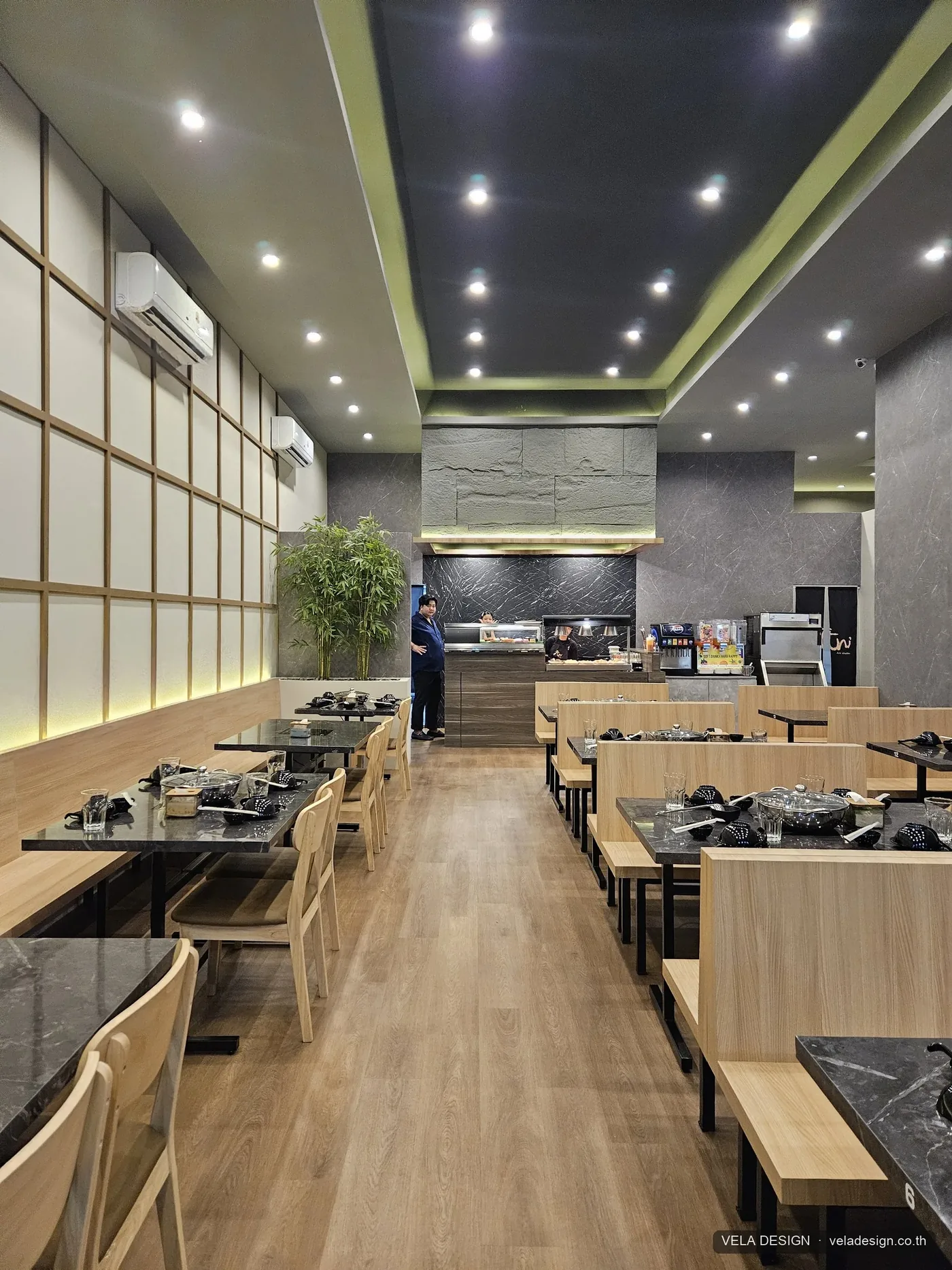 มุมมองแนวตั้งของโซนรับประทานอาหาร Ani Shabu — ผนังซิกเนเจอร์ลายภูเขาซ้อนชั้นและแสง warm light
