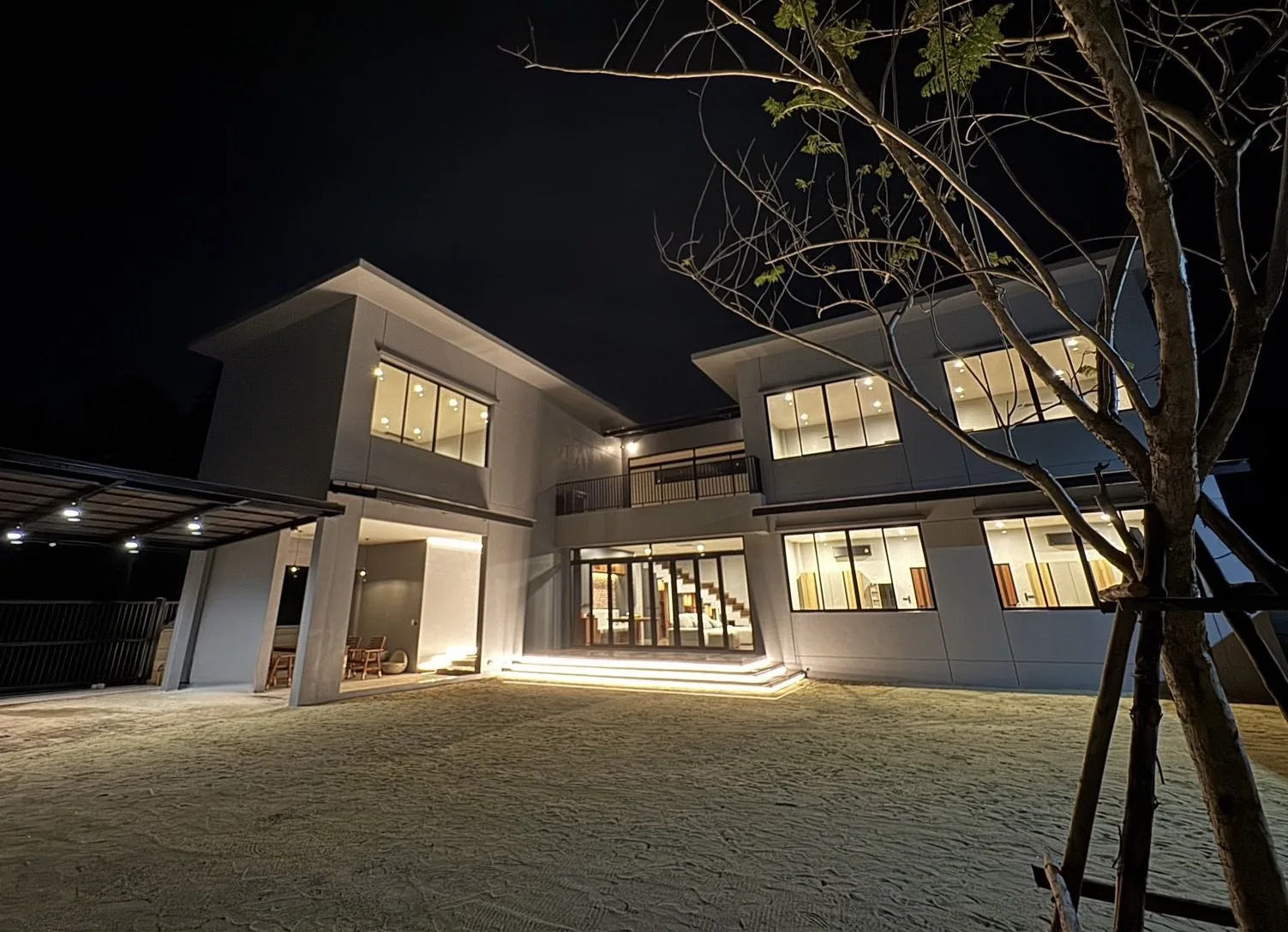 บ้านพักอาศัย สมุทรสงคราม — ด้านหน้าบ้านยามค่ำพร้อมไฟส่องอาคาร